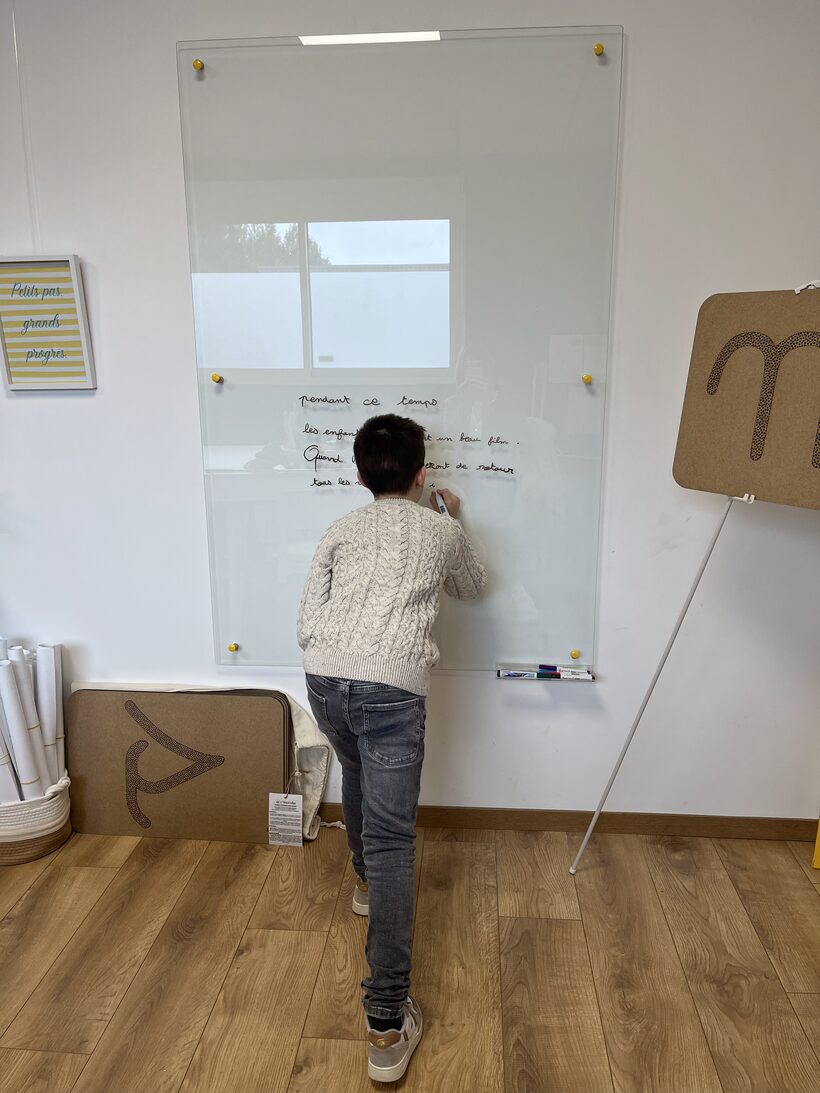 Un enfant s'exerce à l'écriture à l'ardoise